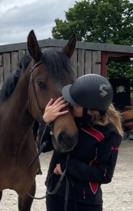 Romane, fondatrice d'Eki Compagnie étreignant un cheval